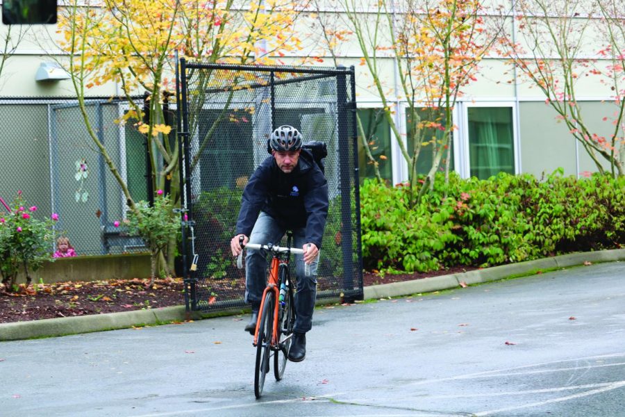 English teacher Alec Duxbury rides his bike. Duxbury rides his bike to school nearly every day -- he knows how important sustainable transportation is to the environment.