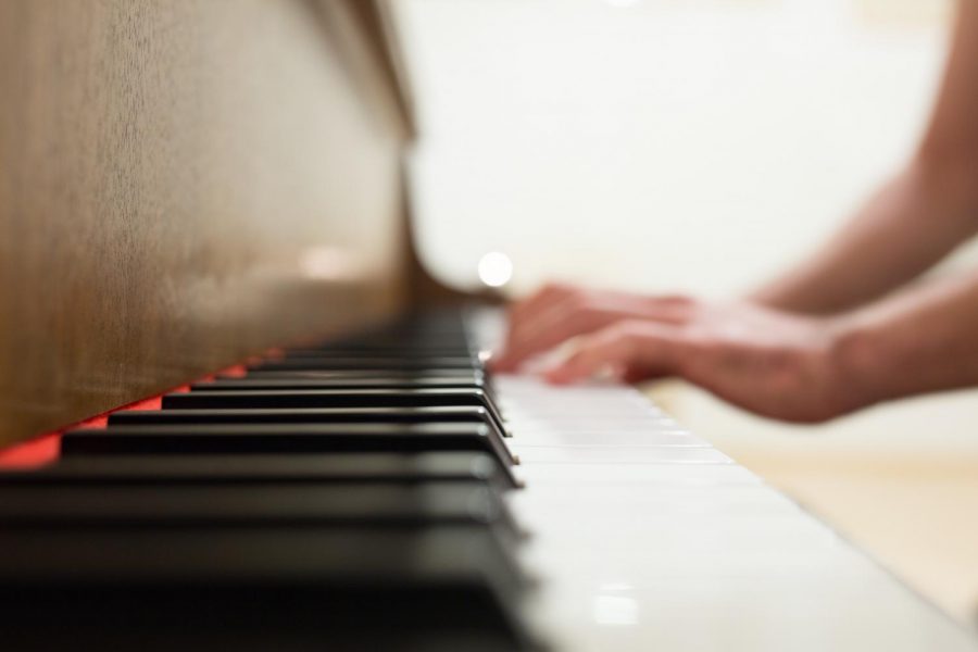 A side profile of a person playing a piano. (Negative Space/Pexels)