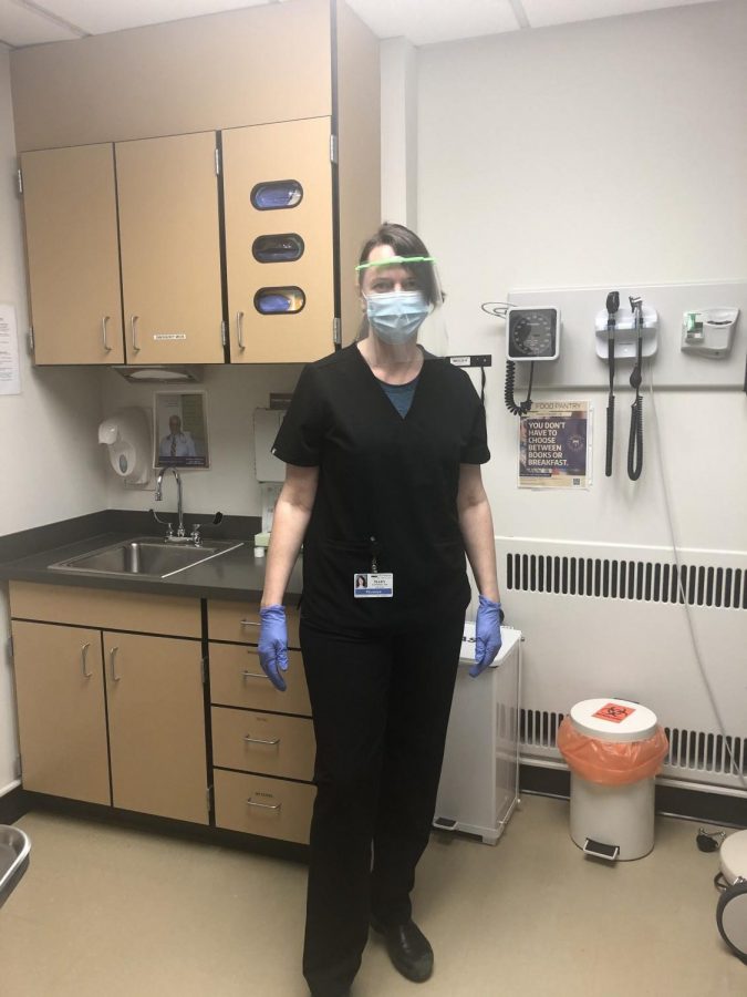 Mollie Kauffman, head of primary and same-day care at a University of Washington clinic,  wears a mask, face shield and gloves to 
evaluate a patient with respiratory symptoms. Kauffman is one of several UPrep parents working in the fight against COVID-19.