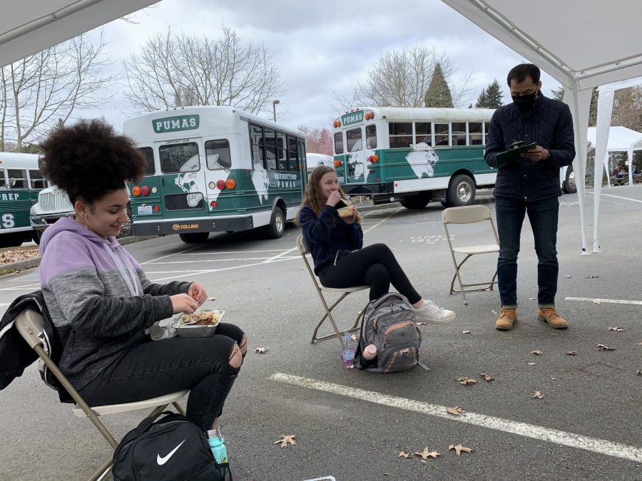  Sophomres Sydney Goitia-Doran and Delia Rossi share a laugh during lunch on campus while Director of Upper School Joel Sohn takes attendance. Students eat socially distanced outside in the faculty parking lot. 