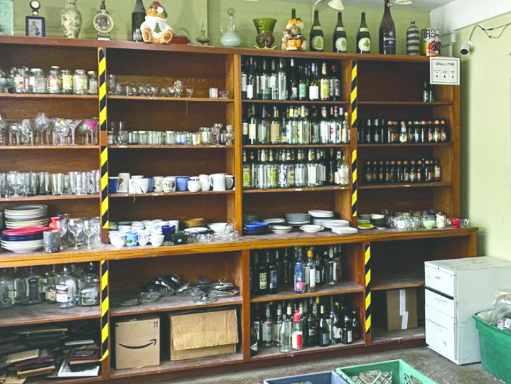 Shelves are lined with bottles, plates, cups and even vases all ready to be smashed. 