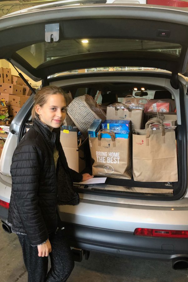 Carly Katzman drops off supplies at the food bank that she had earned by selling cookies.