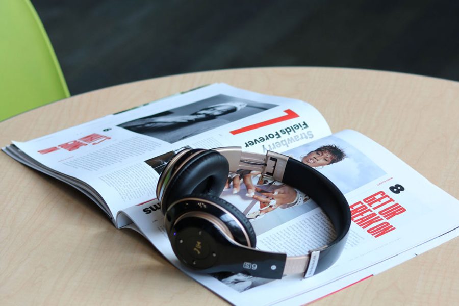 Image of headphones laying on Rolling Stone Magazine, open to pages 54 and 55.
