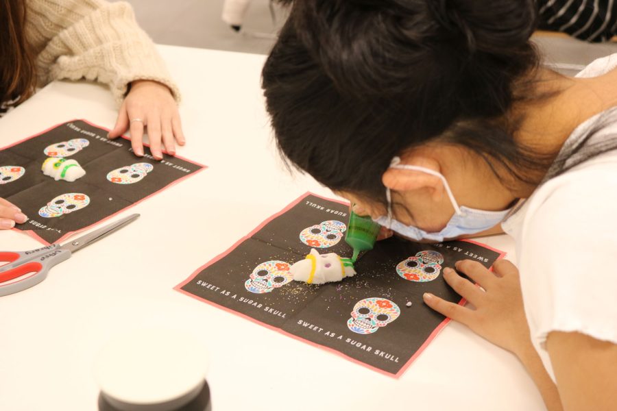 Junior Lauren Hwang decorates a sugar skull with LSU to celebrate Day of the Dead.