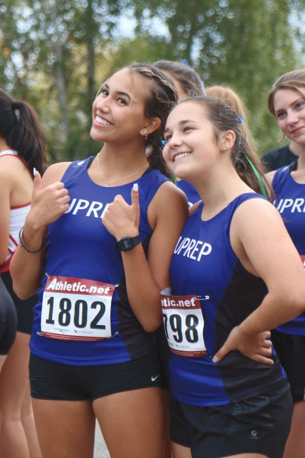 Juniors Sophie Ziedalski and Haley Hoffman smile 
for a picture on the startline before their race.