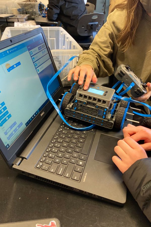Sadie Stoddard and Halle Hollon coding their robot to go through an obstacle course.
