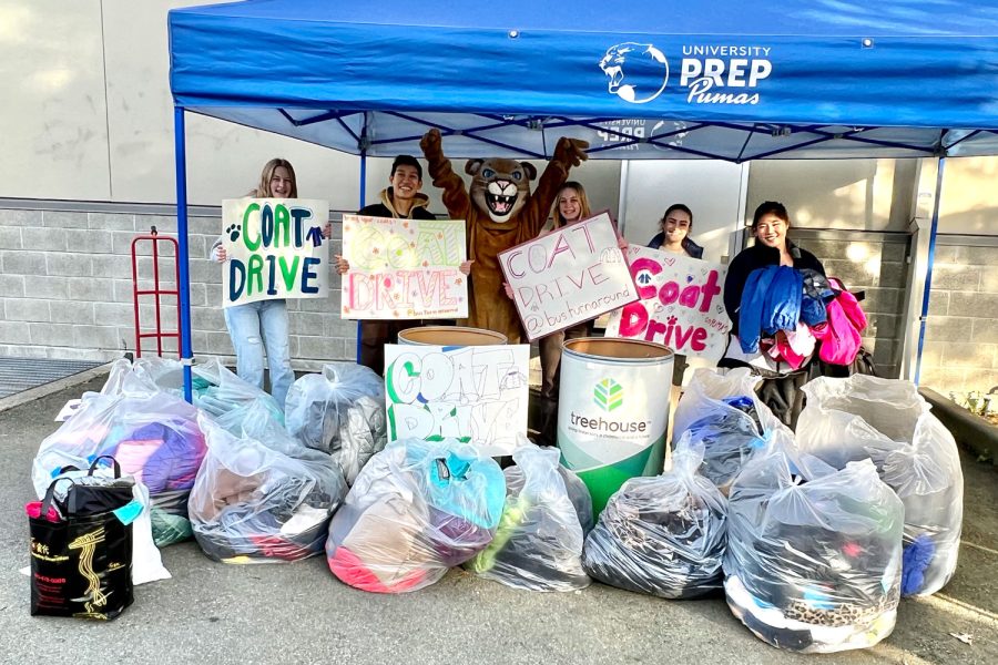 Students of Service club members holding their signs next to bags of collected coats for the coat drive.

Photo Courtesy: Mary Balmaceda