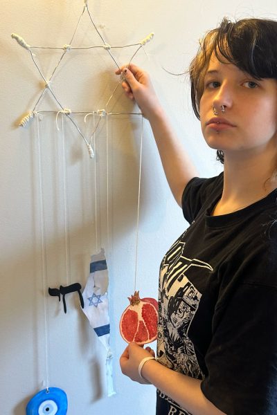 Artist senior Talia Weiss proudly stands next to her mobile after repairing it twice.