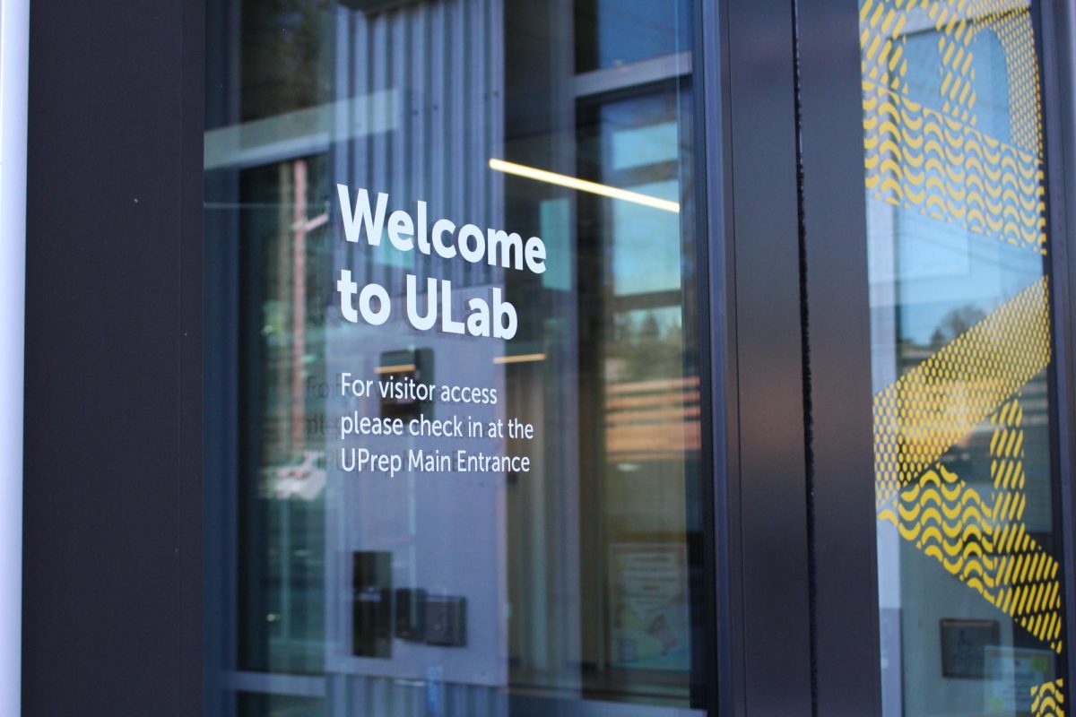 The front door of the ULab displays a note to visitors to check in at the main office. All visitors to the school are accounted for to protect both the staff and students learning and teaching. 