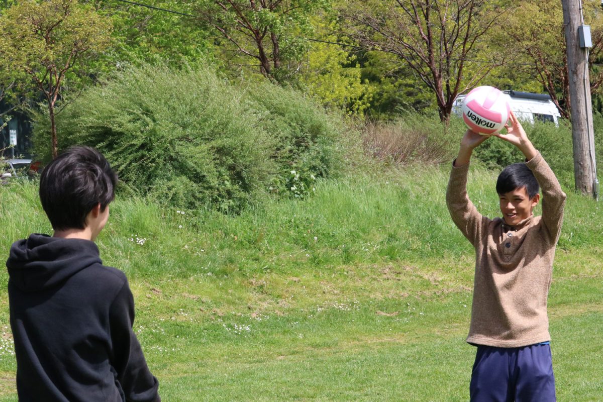 Kellan Lo-Birdsall and Tommy Chang play volleyball.