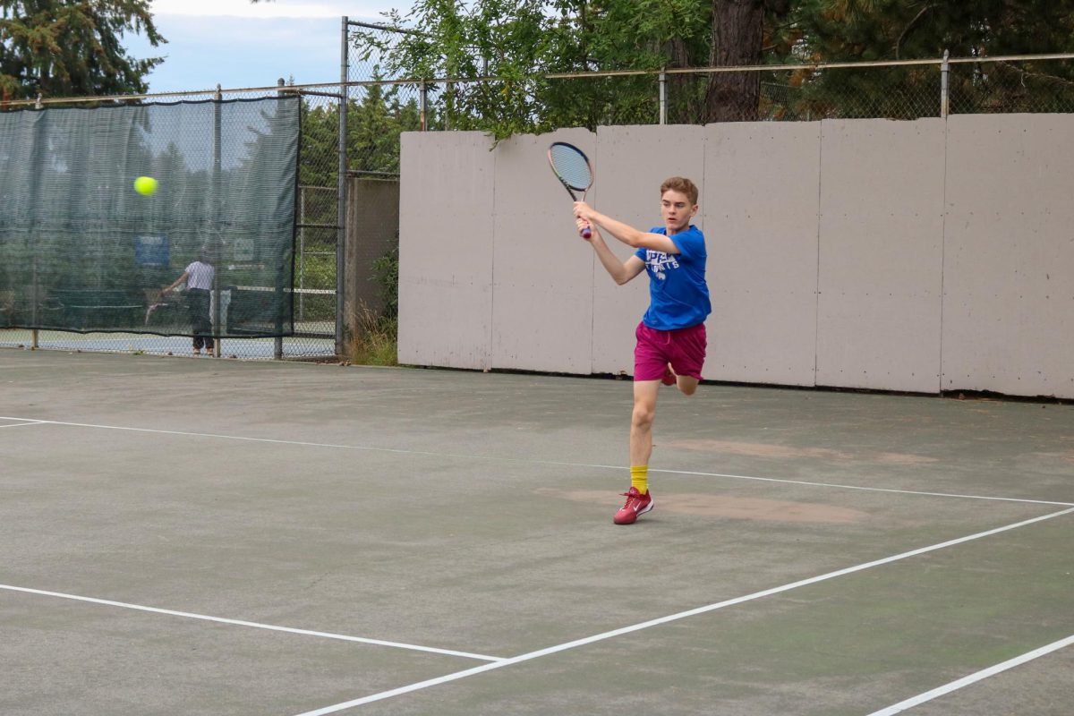 Sophomore Duncan Kilgore plays tennis at Laurelhurst Park with the rest of the JV team.