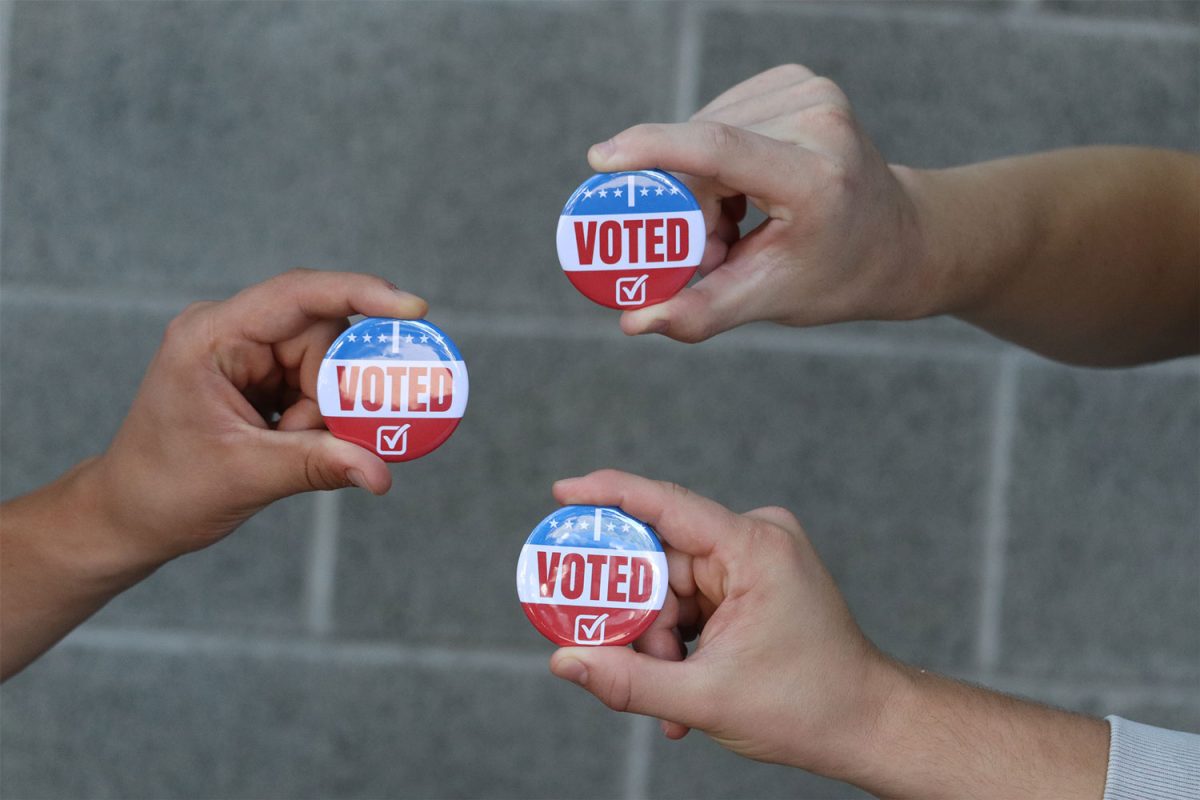 Photo illustration depicting students holding “I voted pins”. 