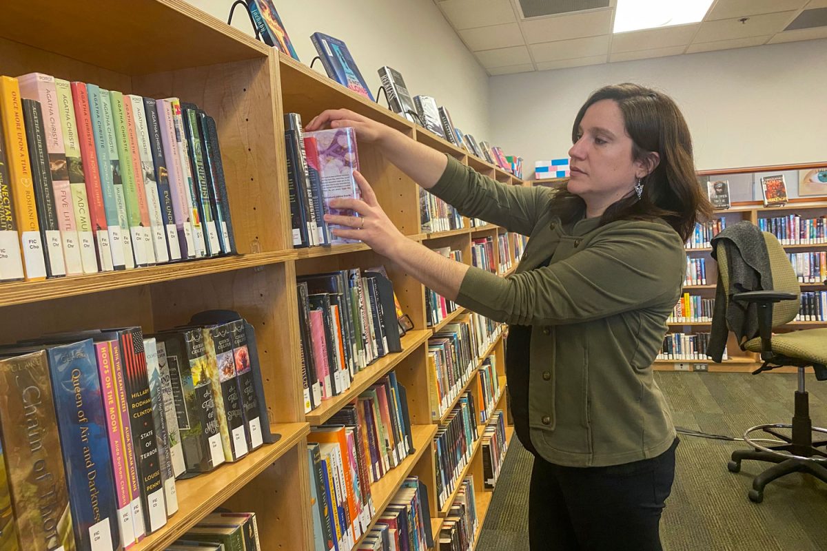 Book contest creator and librarian Aimee Miles organizing the book shelves.