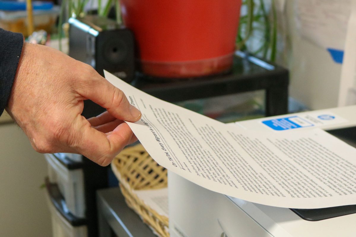 Carl Faucher takes a piece of paper out of the printer on Jan. 14, 2025, in the English office.