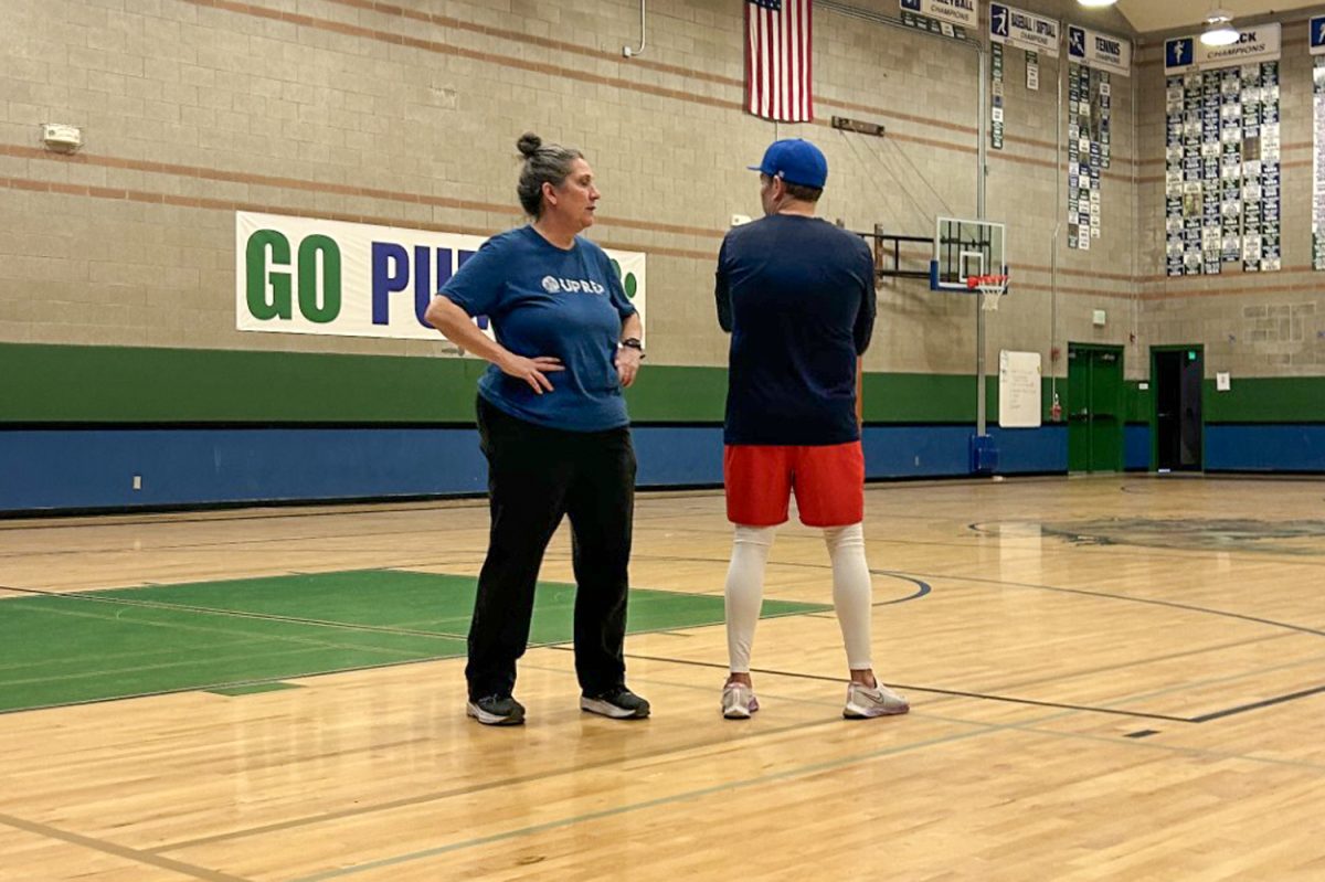 Athletic Director and head baseball coach Rebecca Moe stands next to history teacher and assistant coach Damin Bauer during the team’s first practice. 