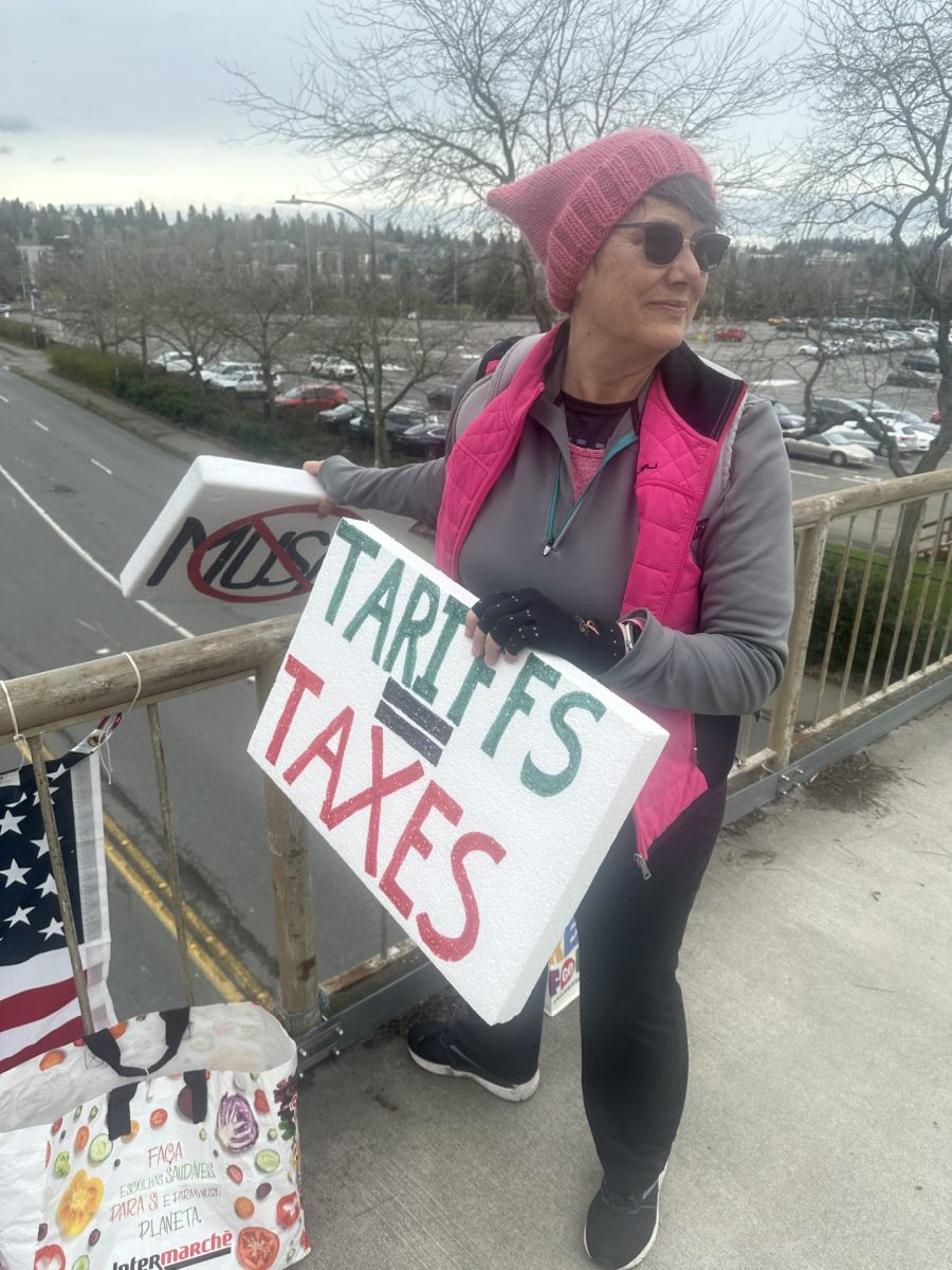 Dawn Lum holds to signs in protest.