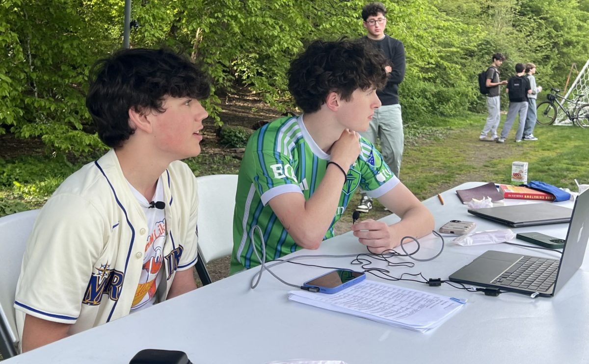 Desmond Payne-Goldman(left) and Davis Glass-Hastings(right) commentate on the varsity game against Bush on April 25 for the University Prep Sports Network. Max Weinstein stands behind them to make sure that everything is going according to plan.