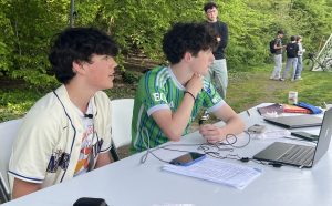 Desmond Payne-Goldman(left) and Davis Glass-Hastings(right) commentate on the varsity game against Bush on April 25 for the University Prep Sports Network. Max Weinstein stands behind them to make sure that everything is going according to plan.