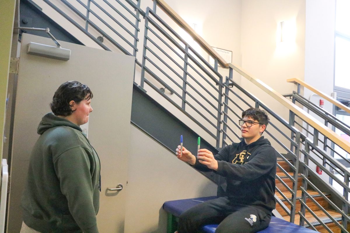 Athletic Trainer Elise Brady guides ninth grader Abraham Starin through a visual concussion recovery exercise.