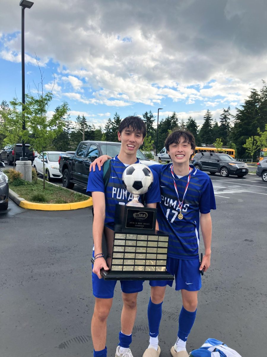 Senior defender Jack DiGiuseppe and sophomore midfielder Jack Hyde hold up the trophy in the parking lot of Federal Way Memorial Field.