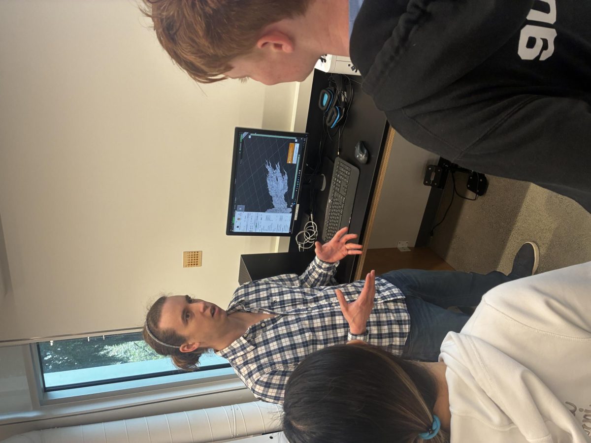 Academic Technology Program Manager June Peters shows Sophomore Beckett Nelson and Freshman Chelan Wang the Computer-Assisted Design software involved in 3D printing. 