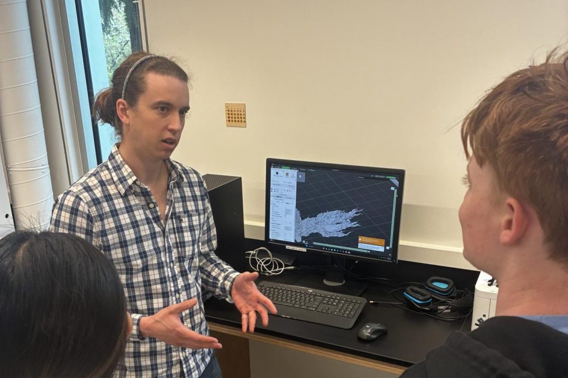 Academic Technology Program Manager June Peters shows Sophomore Beckett Nelson and Freshman Chelan Wang the Computer-Assisted Design software involved in 3D printing. 