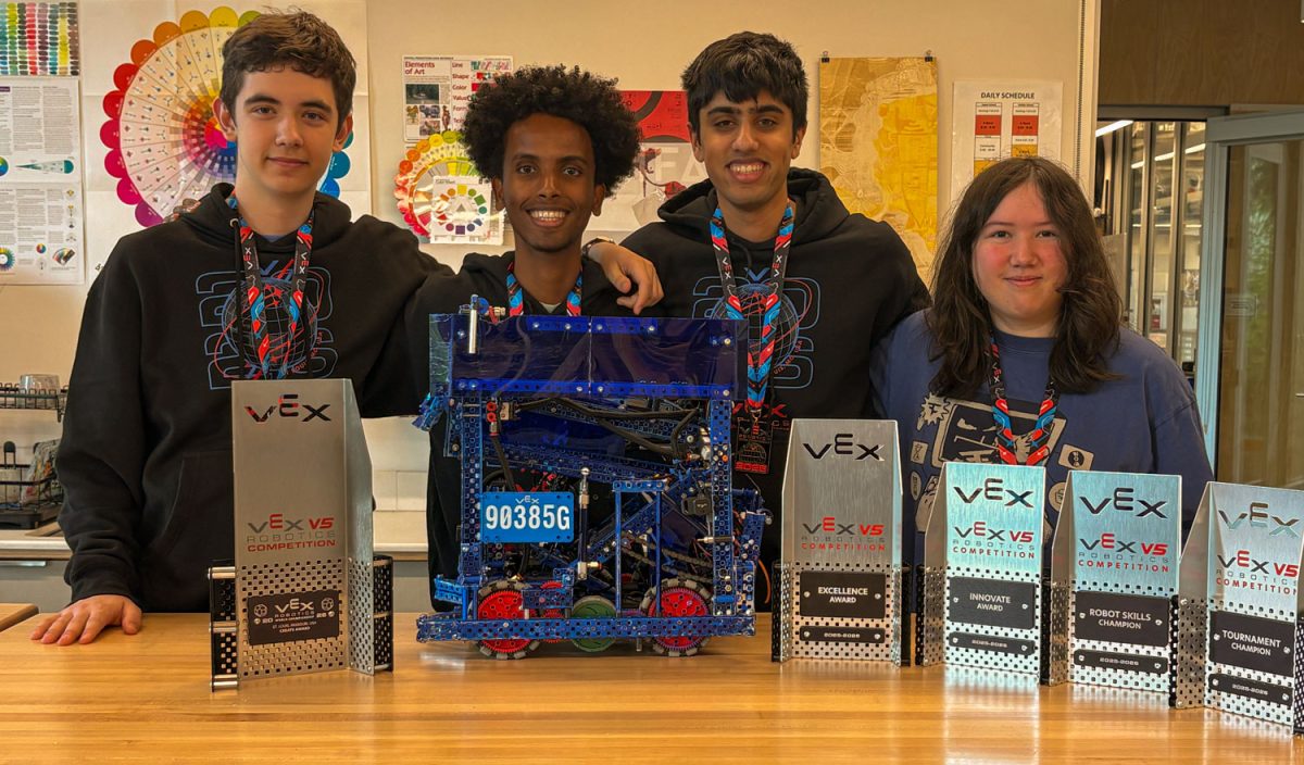 Team 90385G poses with their robot and trophies from the past school year. At worlds, the team won the Create Award, which is given teams with innovative engineering solutions.